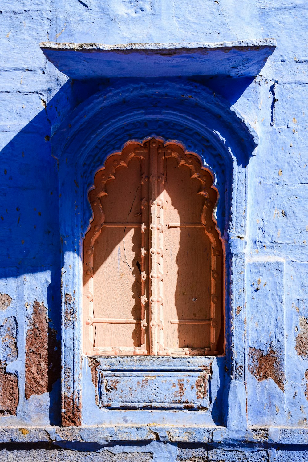 a blue building with a wooden door and window