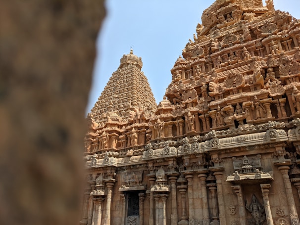An intricately carved stone temple with detailed sculptures and architectural elements, showcasing traditional ancient design. The structure features large towers adorned with figures and motifs that depict historical or mythological scenes.