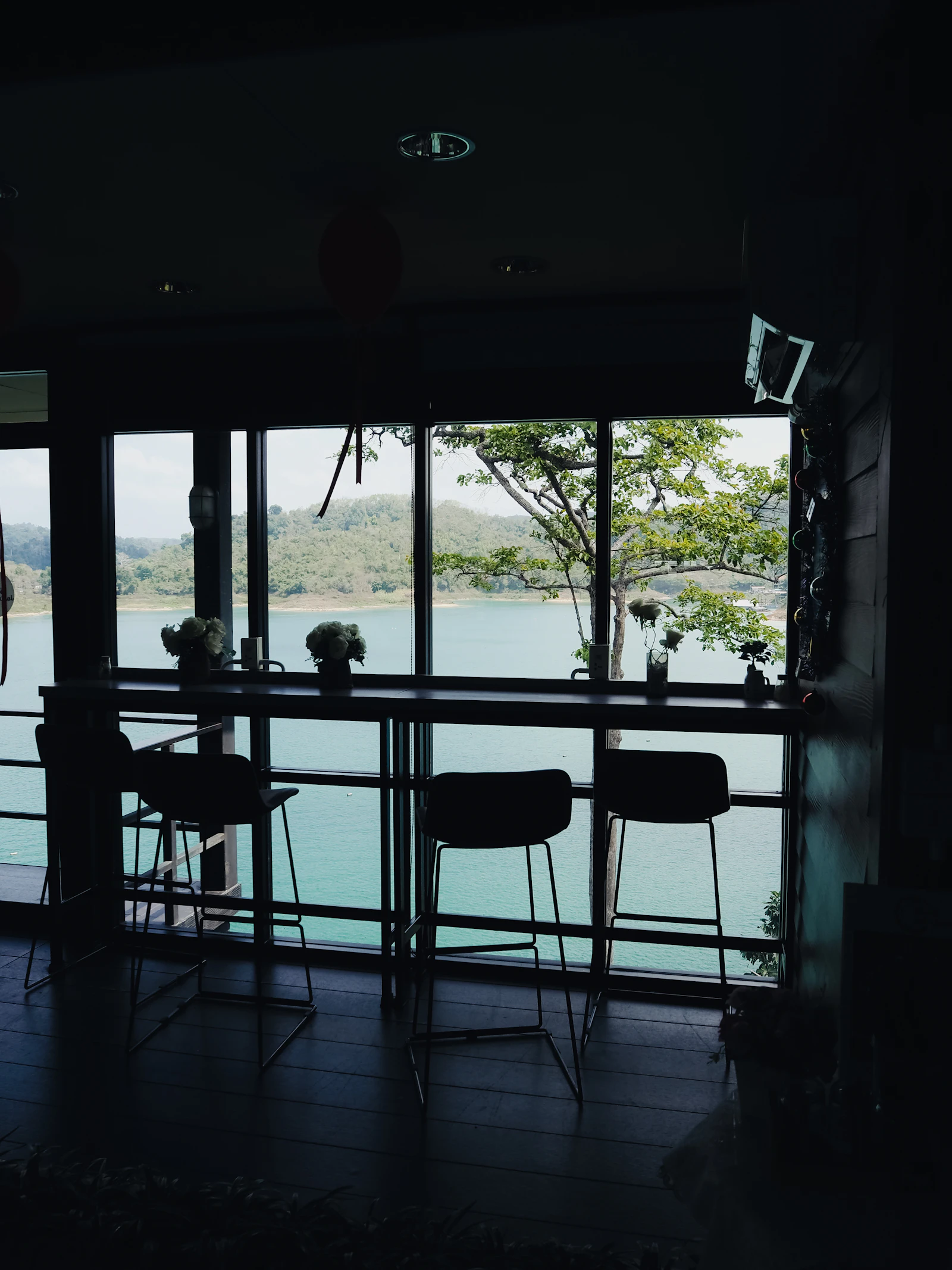 มุมนั่งในร้านที่มีหน้าต่างมองออกไปเห็นผืนน้ำ