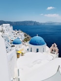 a view of a blue domed building on the edge of a cliff