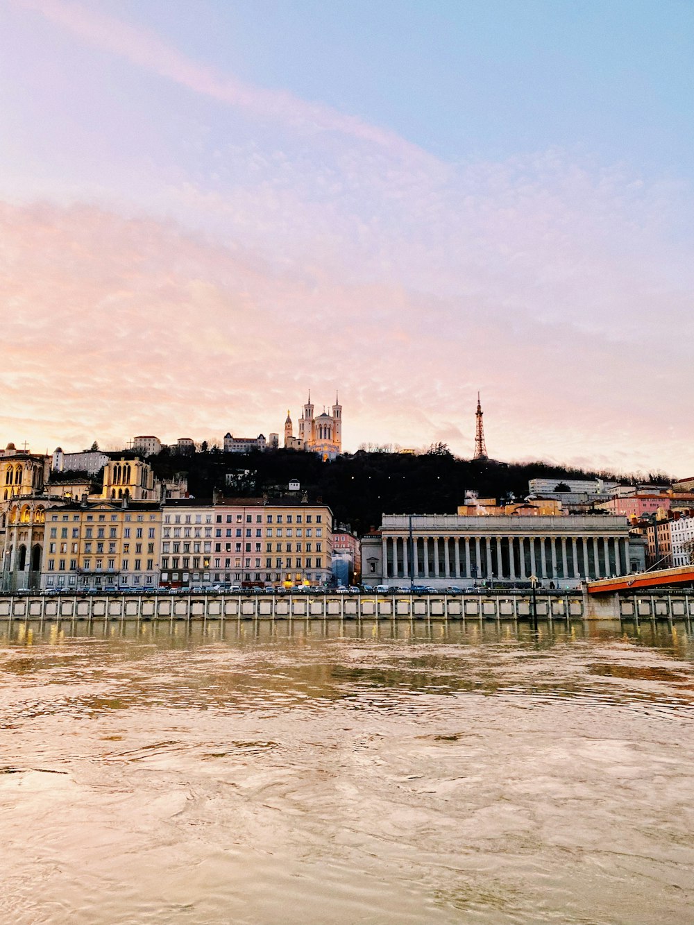 a river with a bridge and a city in the background