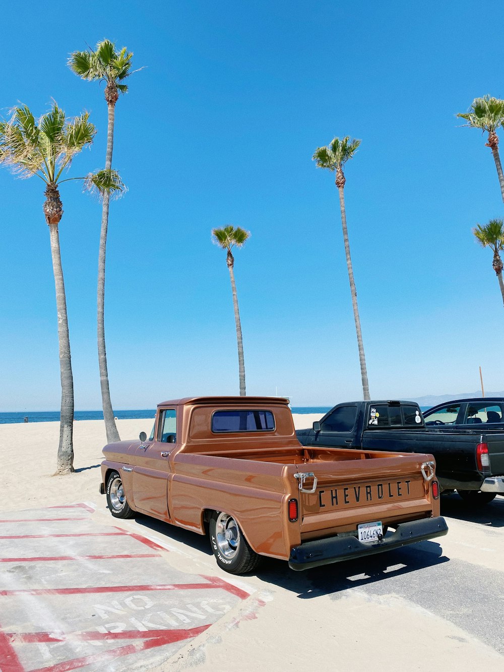 a brown truck parked on top of a sandy beach