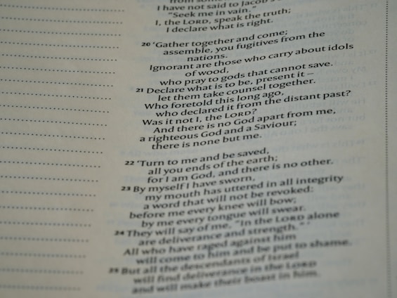 A close-up view of a page from a Bible, featuring passages in both regular and bold text. The text is formatted in a column with numbers preceding certain lines, set against a background of light-colored paper.