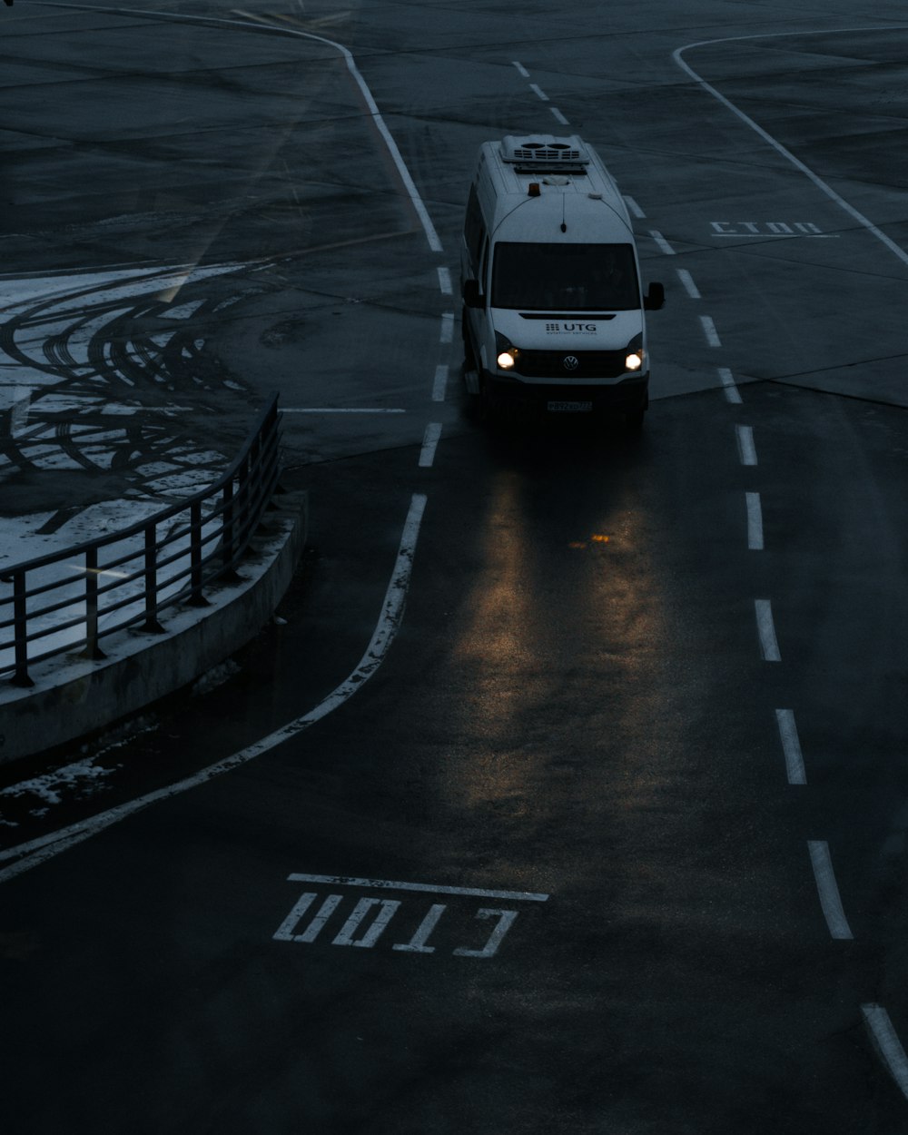 a white van driving down a street next to an airport