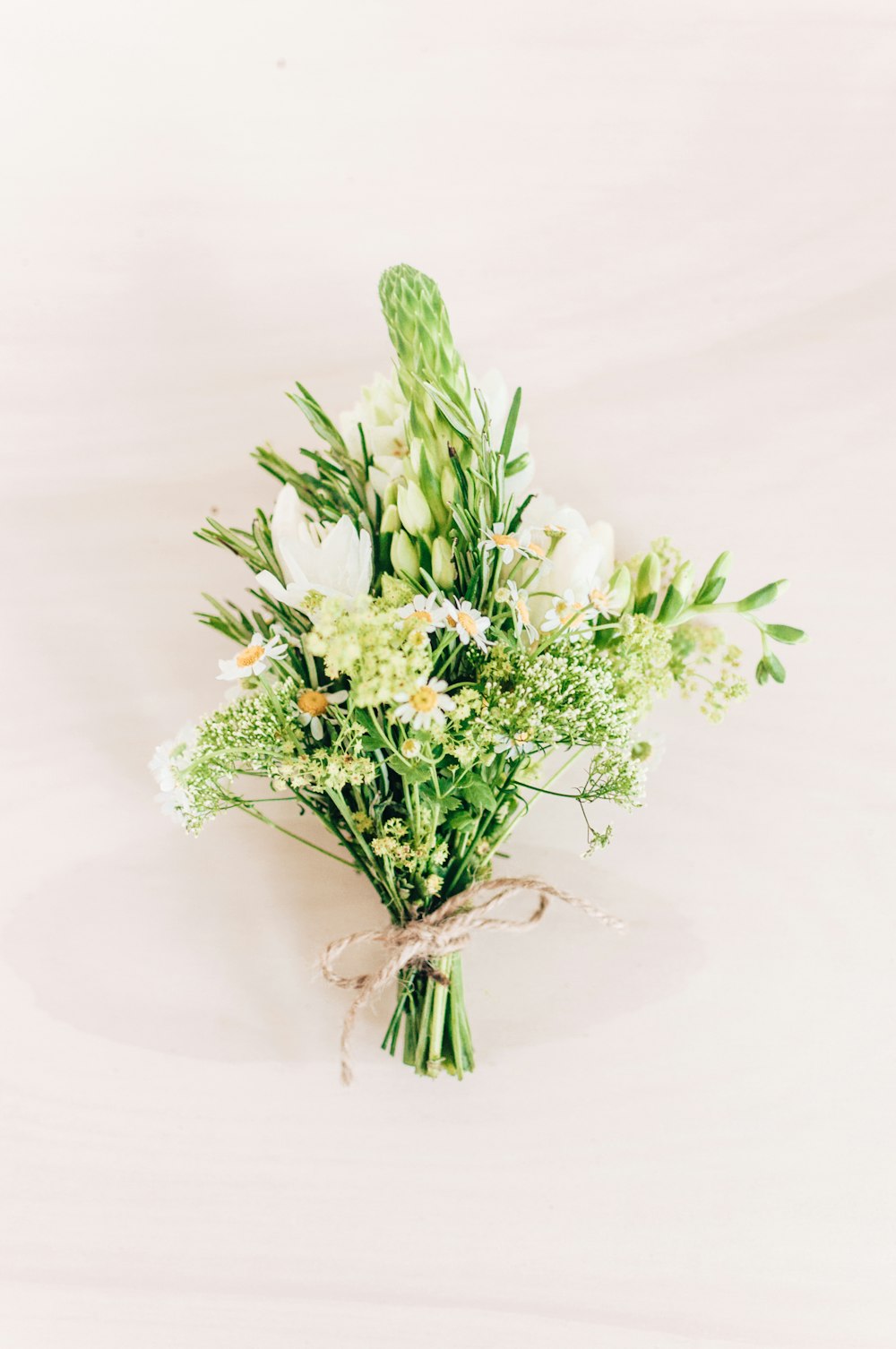 a bouquet of white flowers tied to a string
