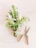 Close-up of a rustic bouquet featuring wildflowers and greenery tied with natural twine on a wooden table.