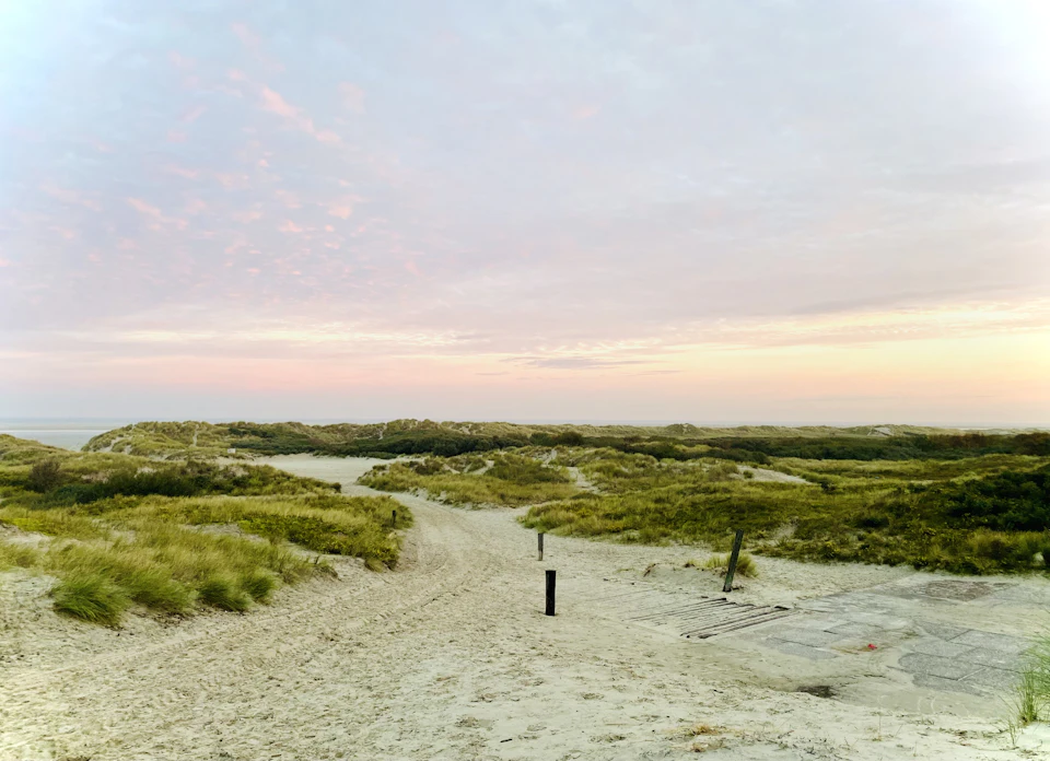 Zandpad dat door de duinen slingert in de schemering
