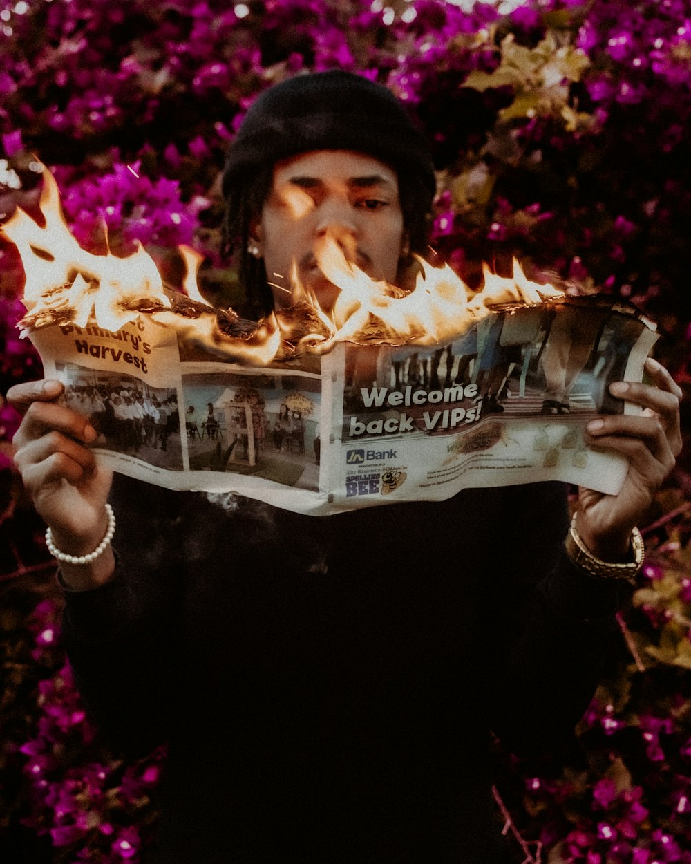 a woman reading a newspaper with flames coming out of it