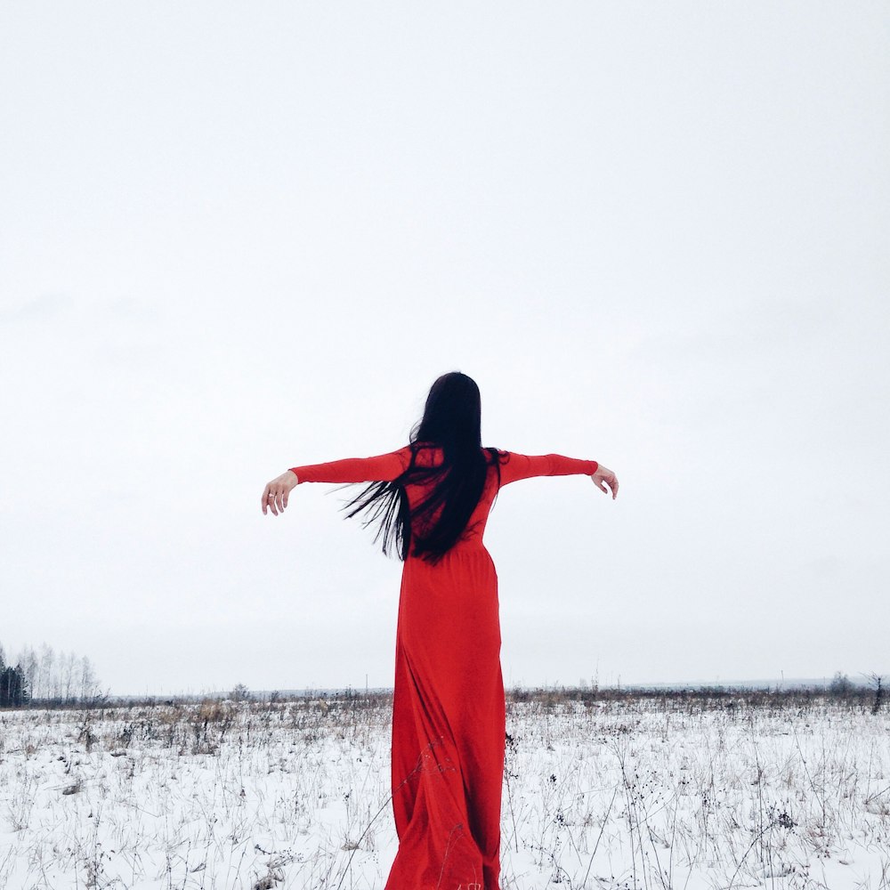 Eine Frau im roten Kleid steht im Schnee