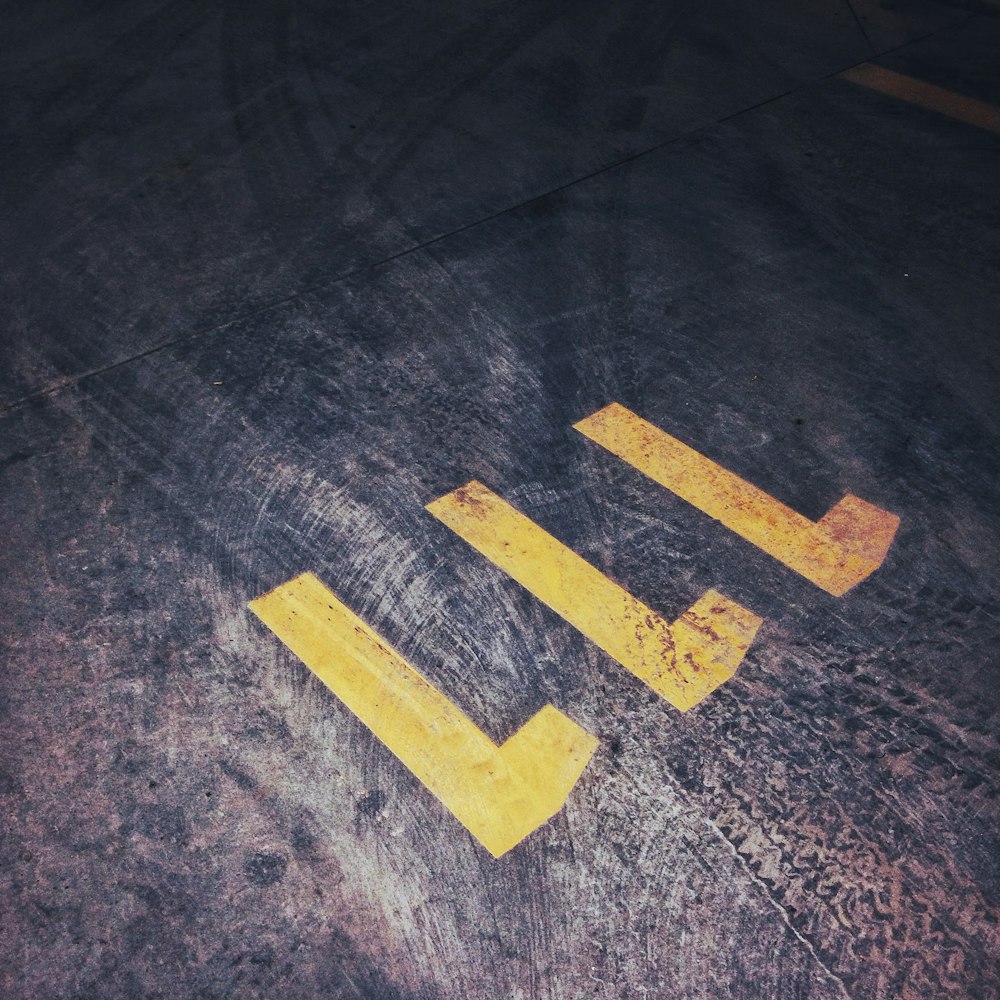 a parking lot with yellow painted arrows on it