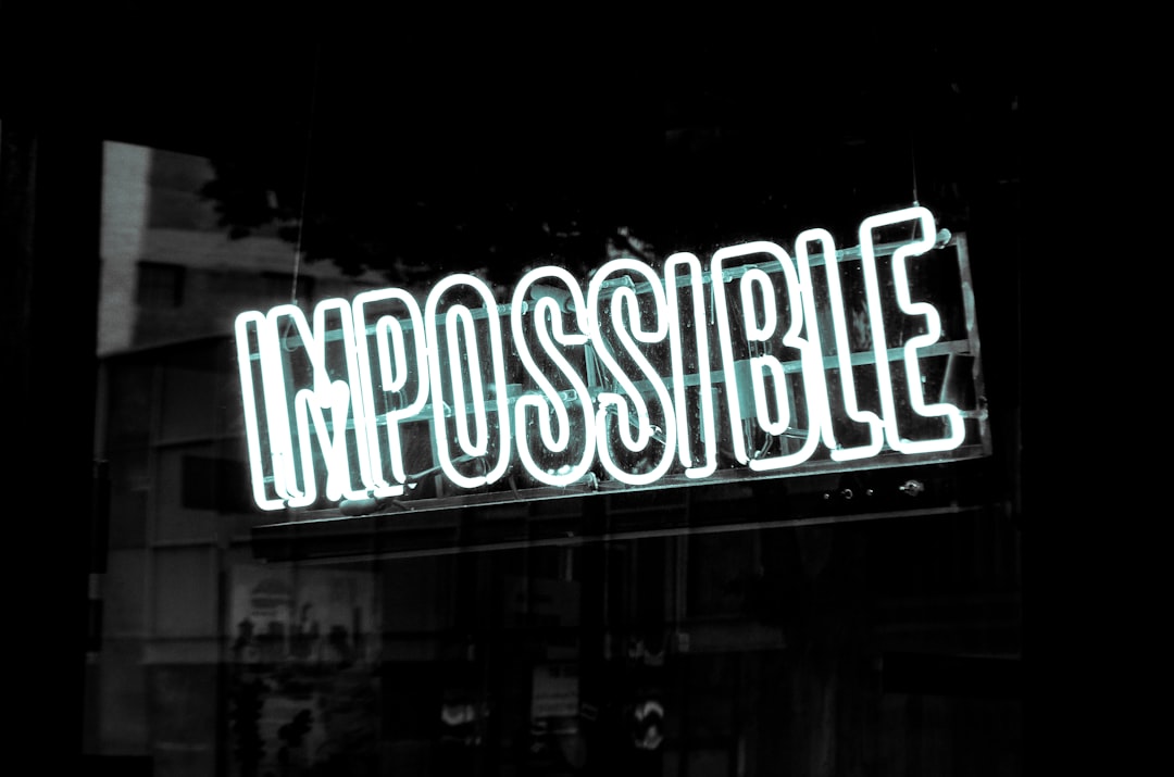 a neon sign that reads impossible visible in a window