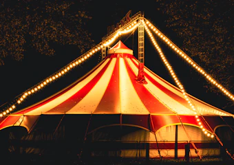 Striped circus tent lit up at night