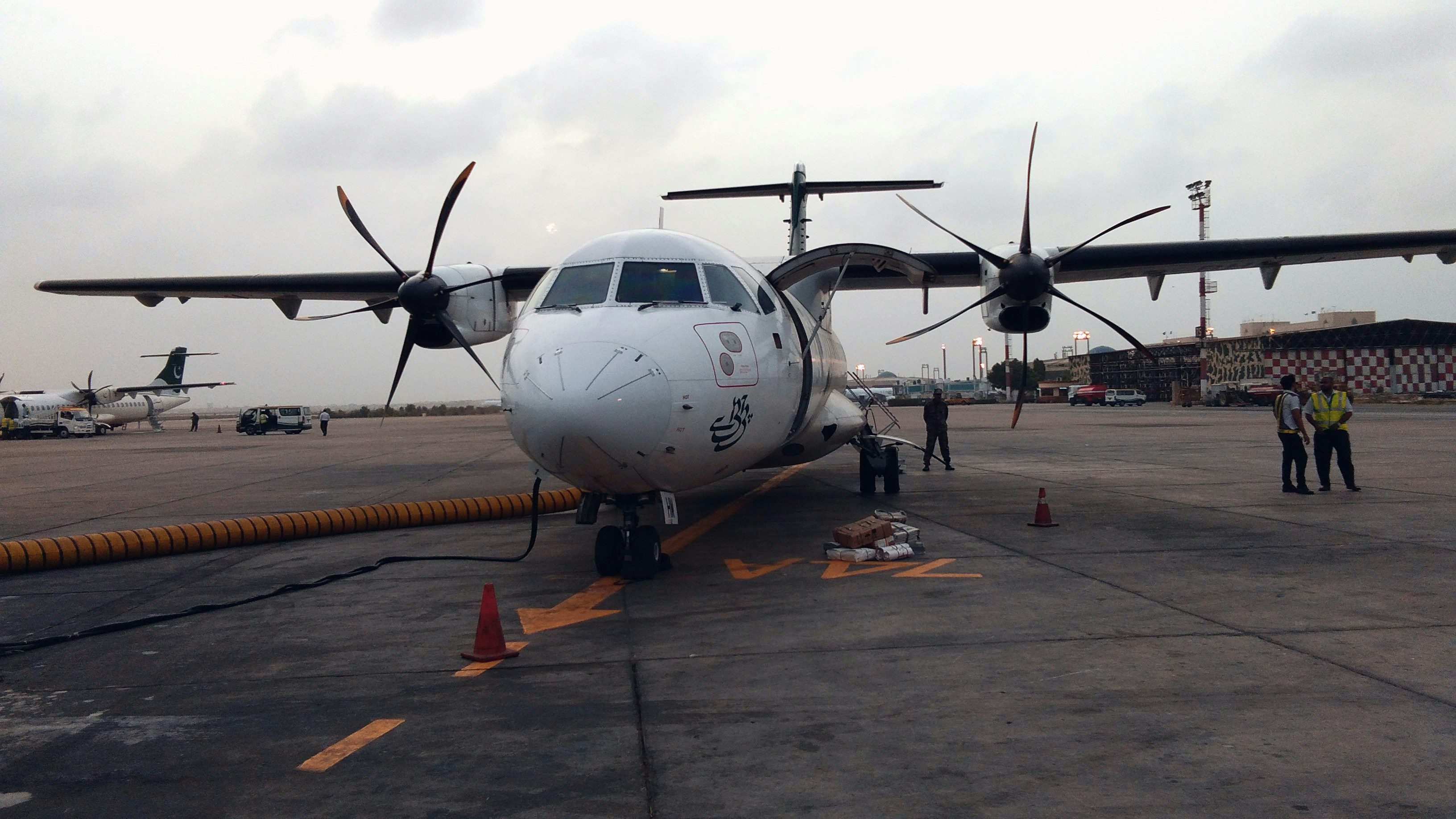 a large propeller plane sitting on top of an airport tarmac, 