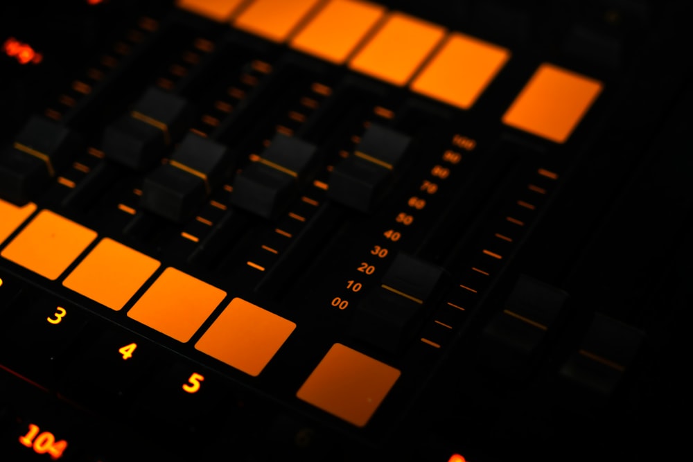 a close up of a sound board with orange lights