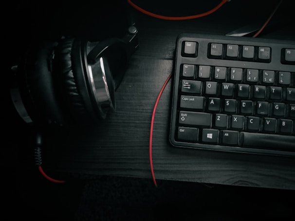 A sleek budget keyboard set up on a modern desk with headphones and a microphone nearby.