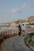 Couple enjoying a private tour along a sun-dappled coastal path in Spain