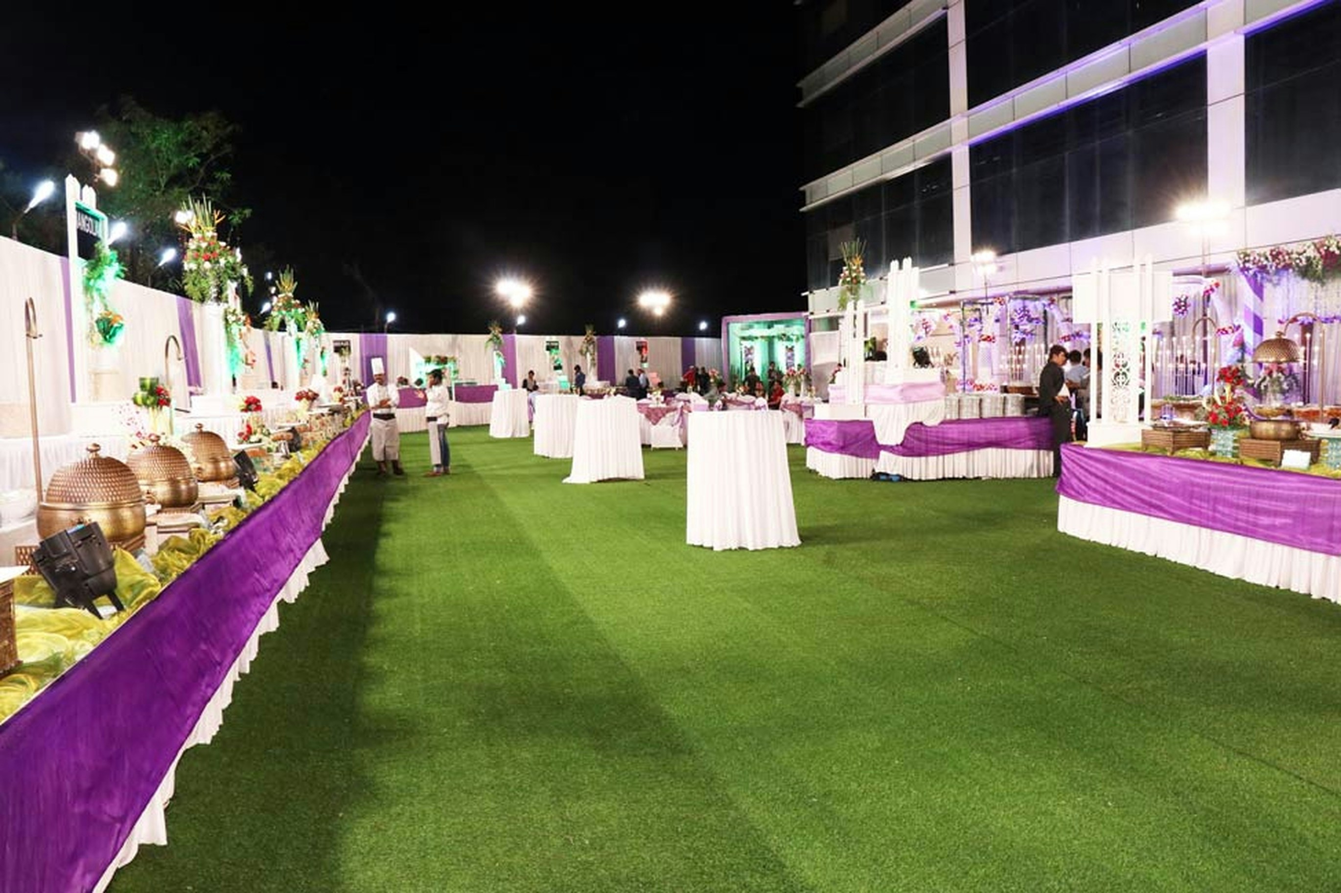 Large-scale outdoor catering setup with rows of food service counters, organized serving stations, and crowds at a political gathering