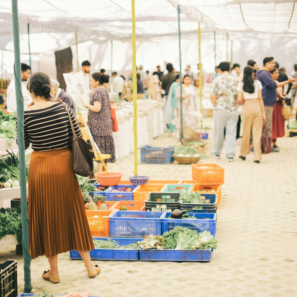 a group of people shopping at a farmers market