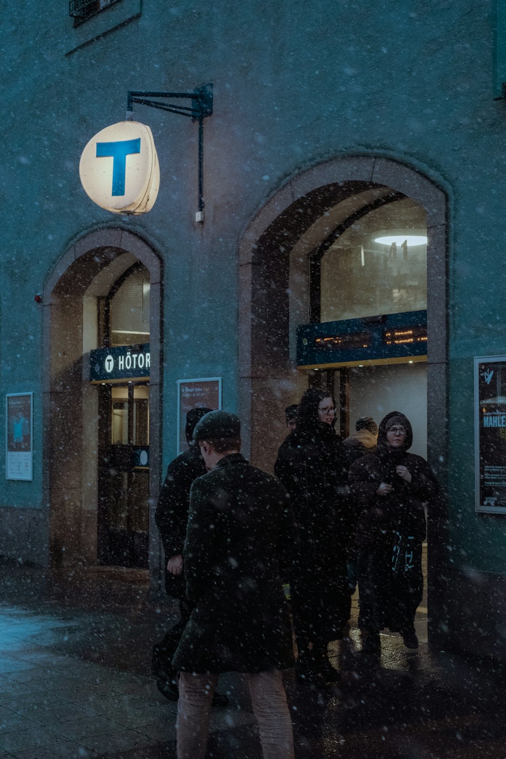 a group of people standing outside of a building in the snow