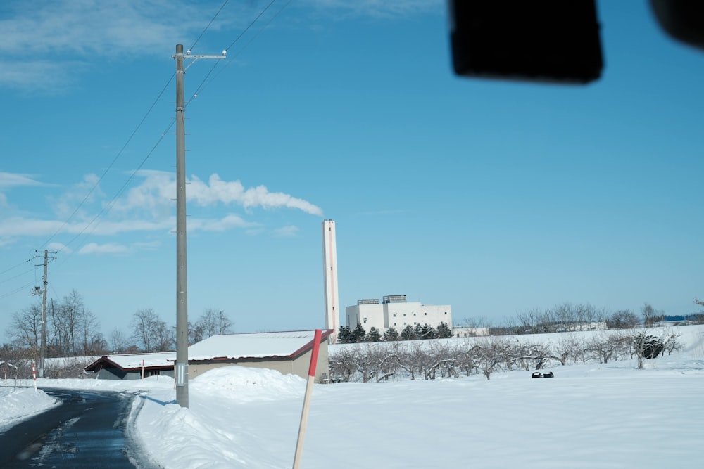 a snowy road with a building in the background