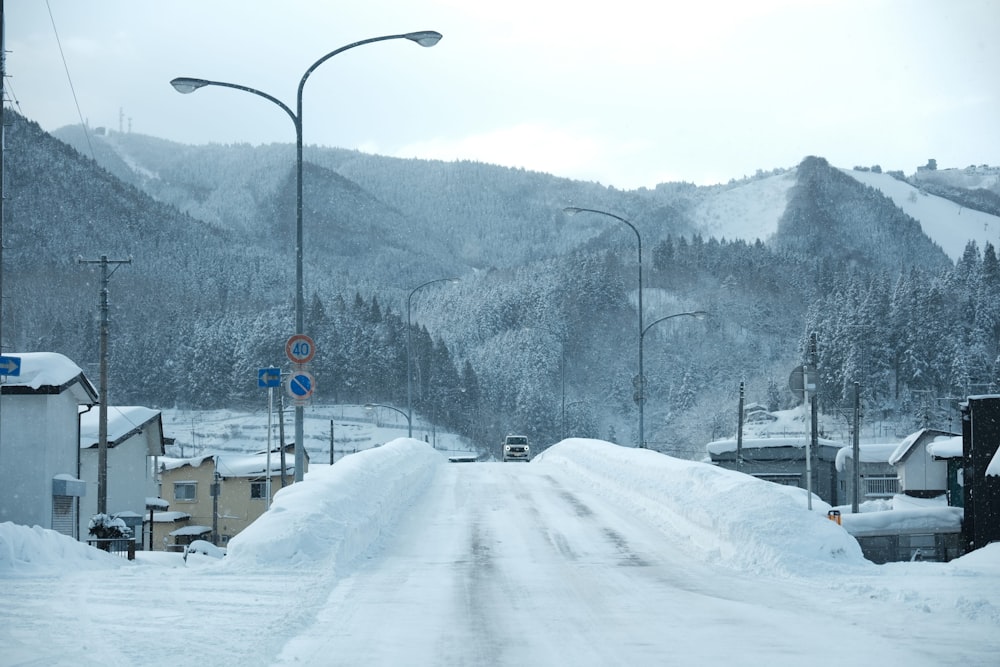 a snow covered road with a mountain in the background