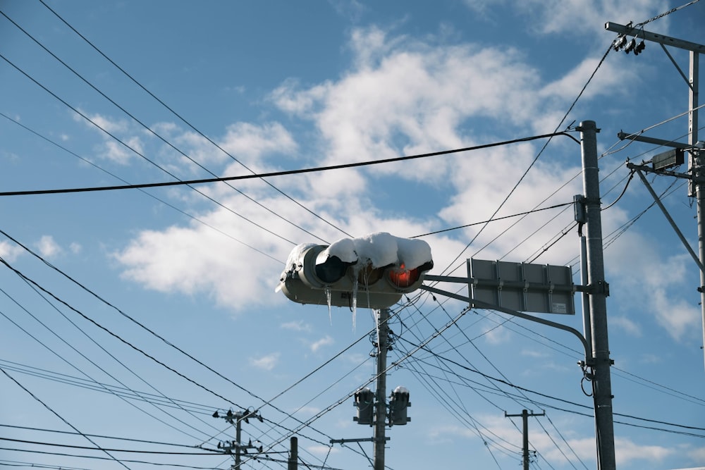 a traffic light on a pole with power lines in the background