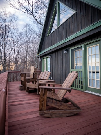 a couple of wooden chairs sitting on top of a wooden deck