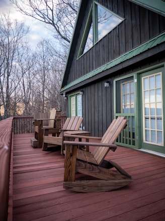 a couple of wooden chairs sitting on top of a wooden deck