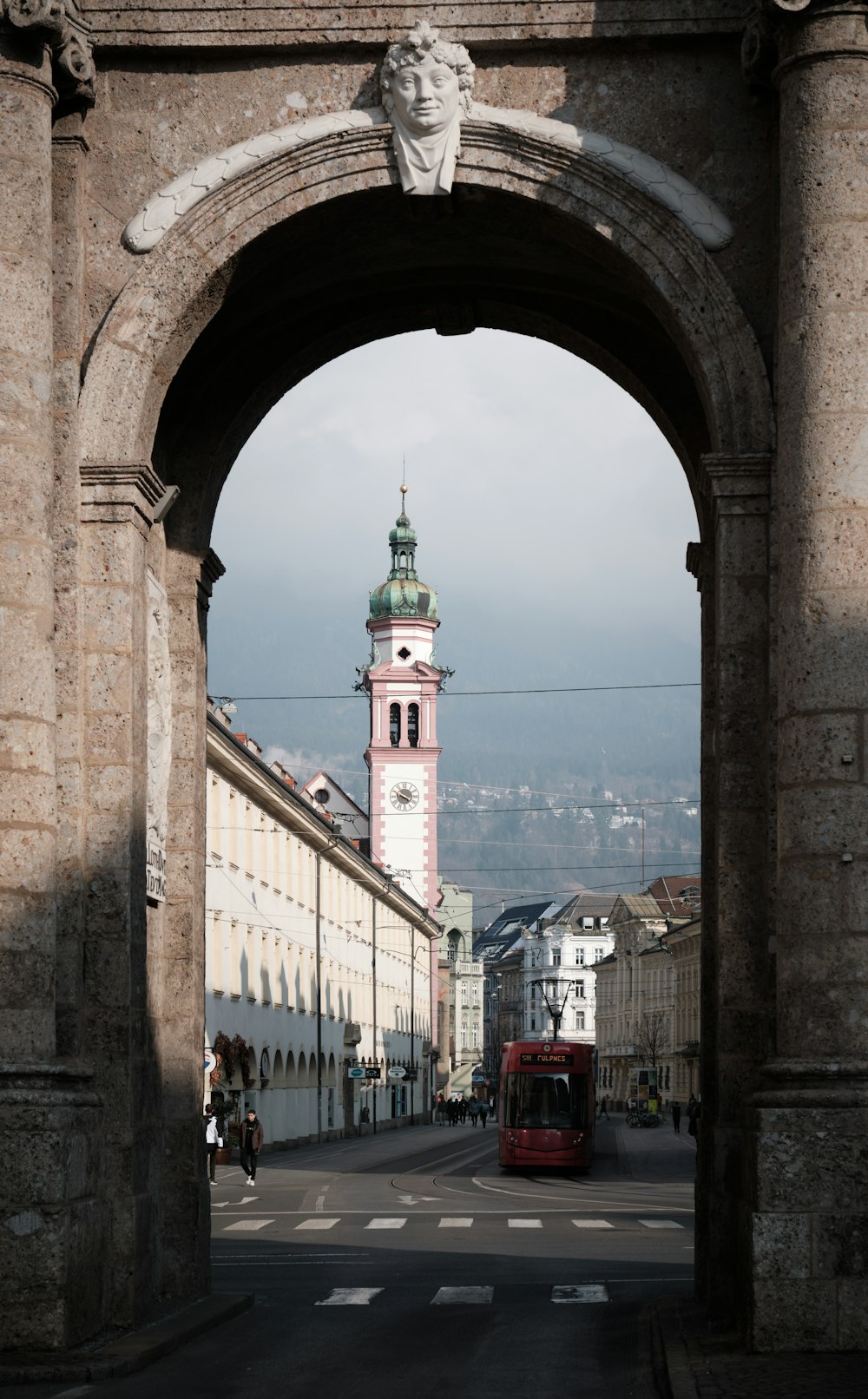 Una strada cittadina con una torre dell'orologio sullo sfondo