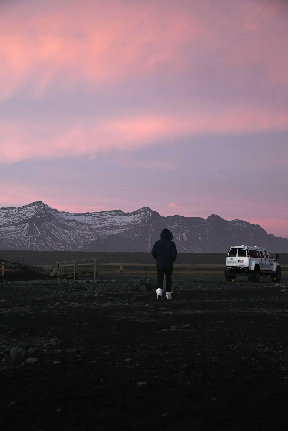 Una persona in piedi in un campo con un camion sullo sfondo