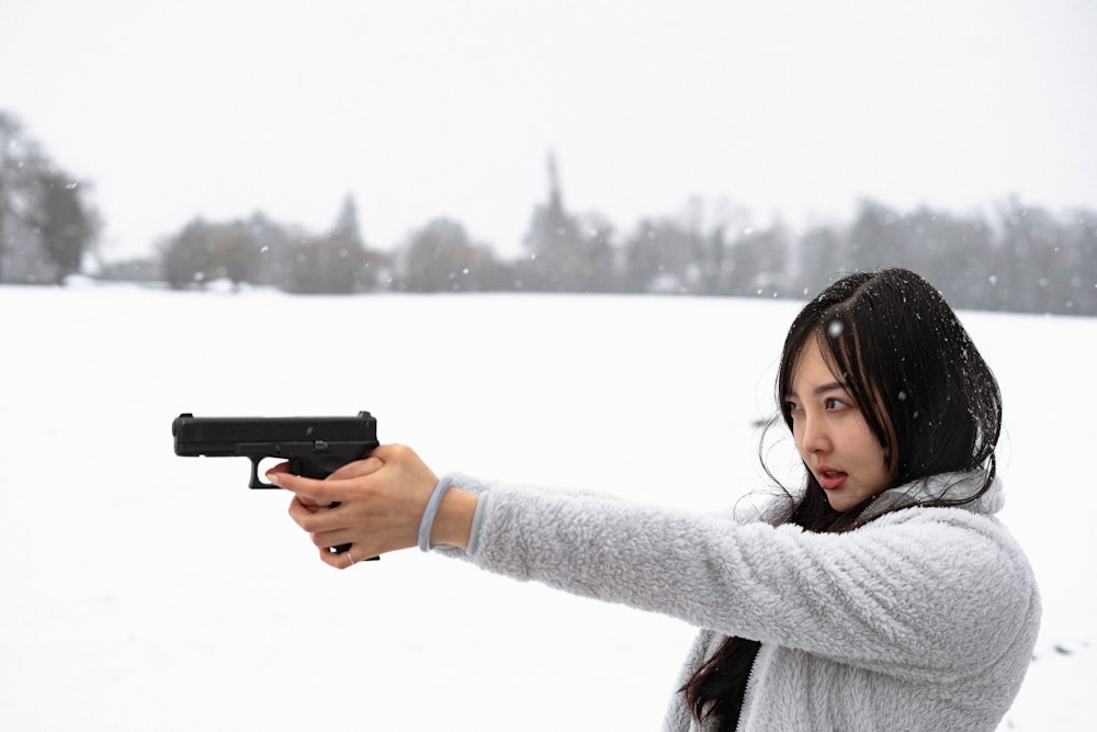 a woman holding a gun in the snow