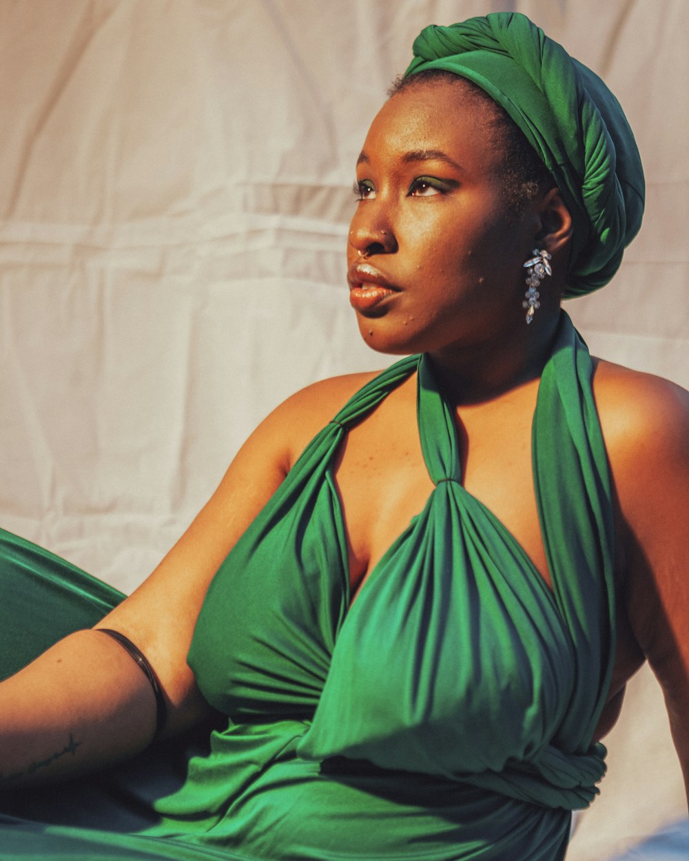 a woman in a green dress sitting on a chair