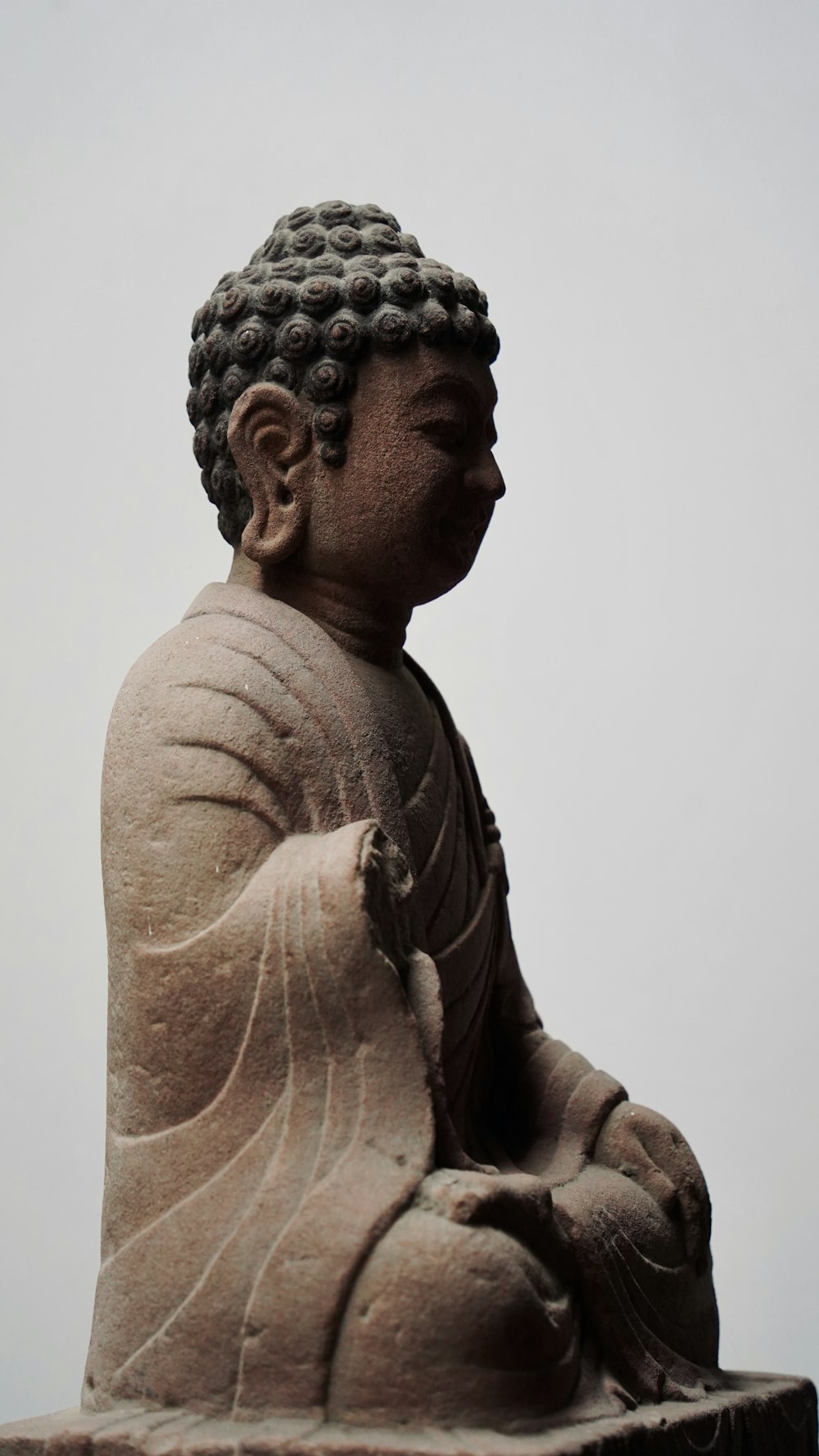 a buddha statue sitting on top of a wooden table