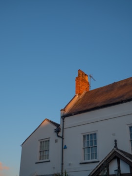Wide shot of a house with a newly installed roof and clean chimney stack.