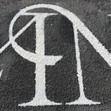 Close-up of a bold, sans-serif street sign with a subtle grain effect on a beige background.