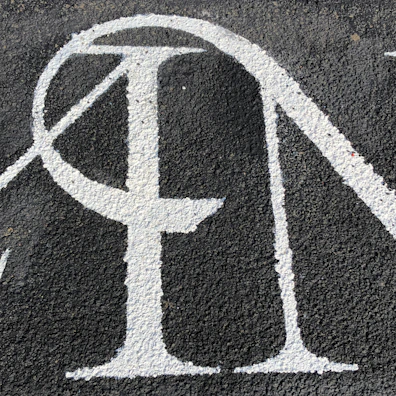 Close-up of a bold, sans-serif street sign with a subtle grain effect on a beige background.