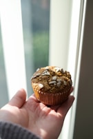 A cozy scene of a person enjoying a healthy snack in a sunlit kitchen.