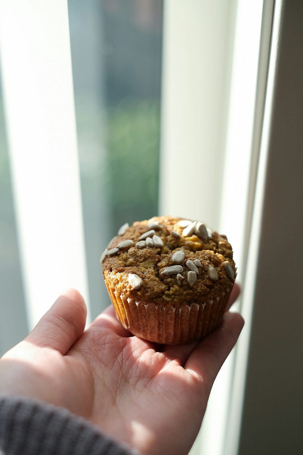 a person holding a muffin in their hand