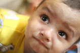 Close-up of a cheerful toddler wearing a vibrant, patterned outfit with fun animal prints.
