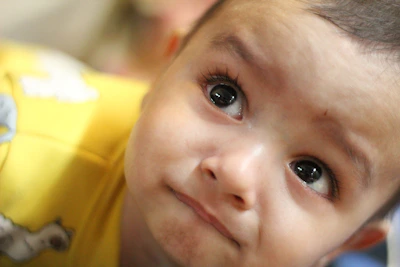 Close-up of a cheerful toddler wearing a vibrant, patterned outfit with fun animal prints.