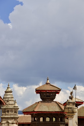 A skilled architect reviewing traditional Tamil architectural blueprints with a backdrop of Tiruvannamalai hills.