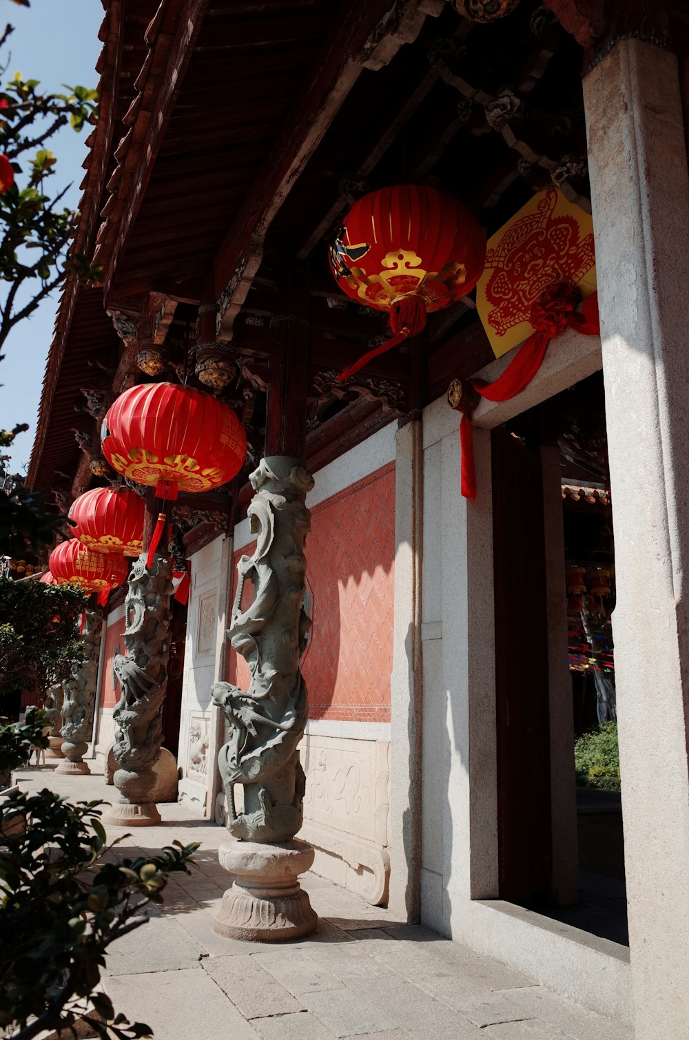 a row of red lanterns hanging from the side of a building