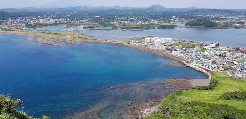 a large body of water surrounded by a lush green hillside