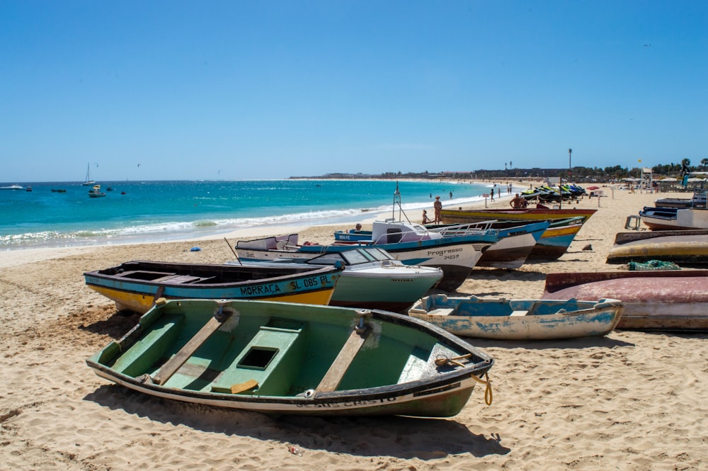 a group of boats sitting on top of a sandy beach