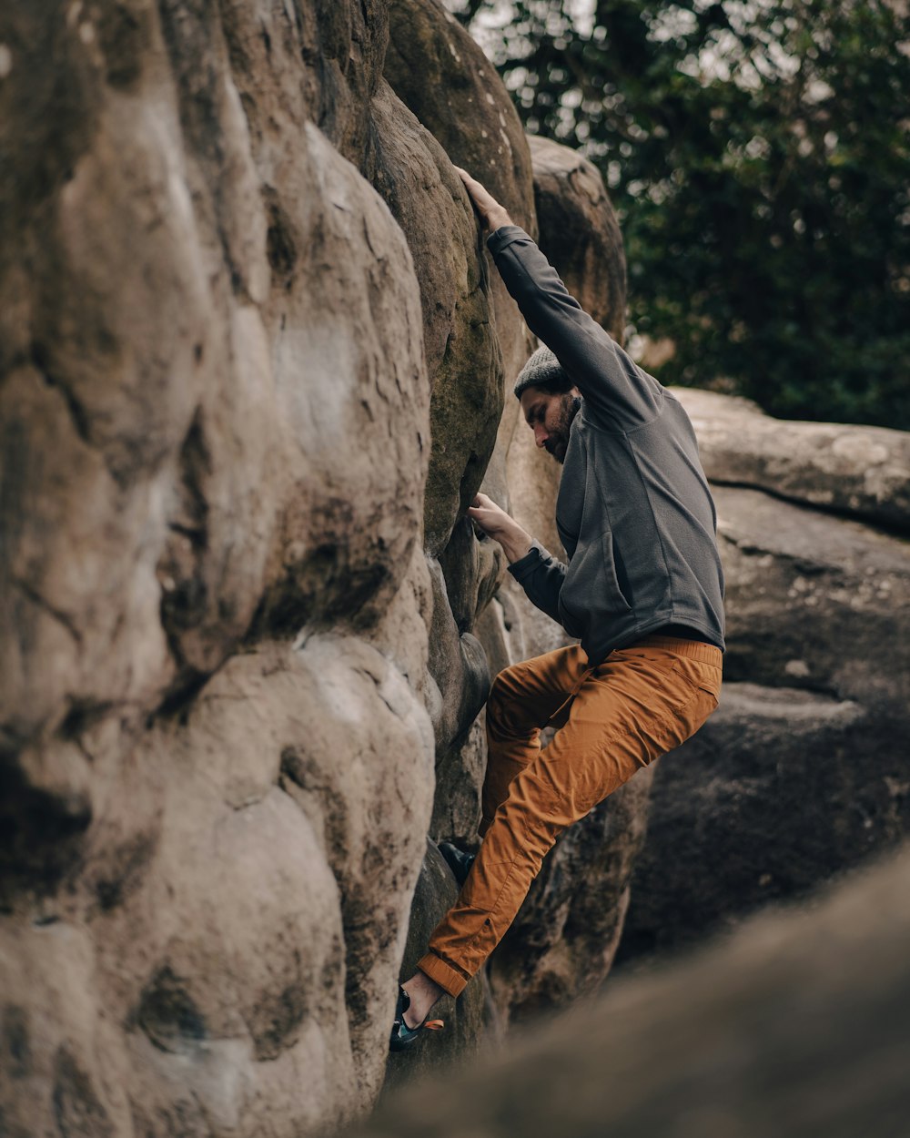 a man climbing up the side of a large rock