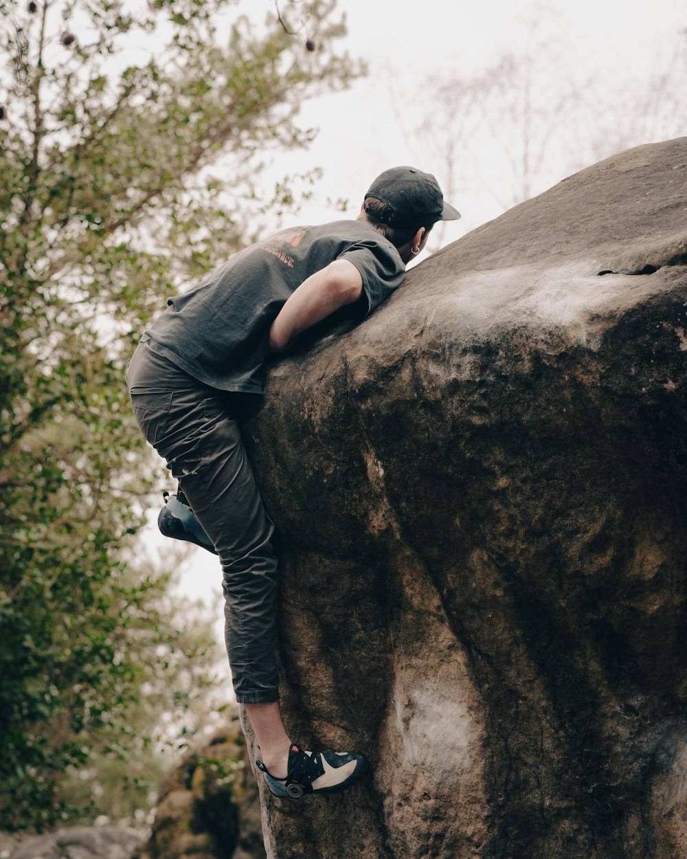 a man climbing up the side of a large rock