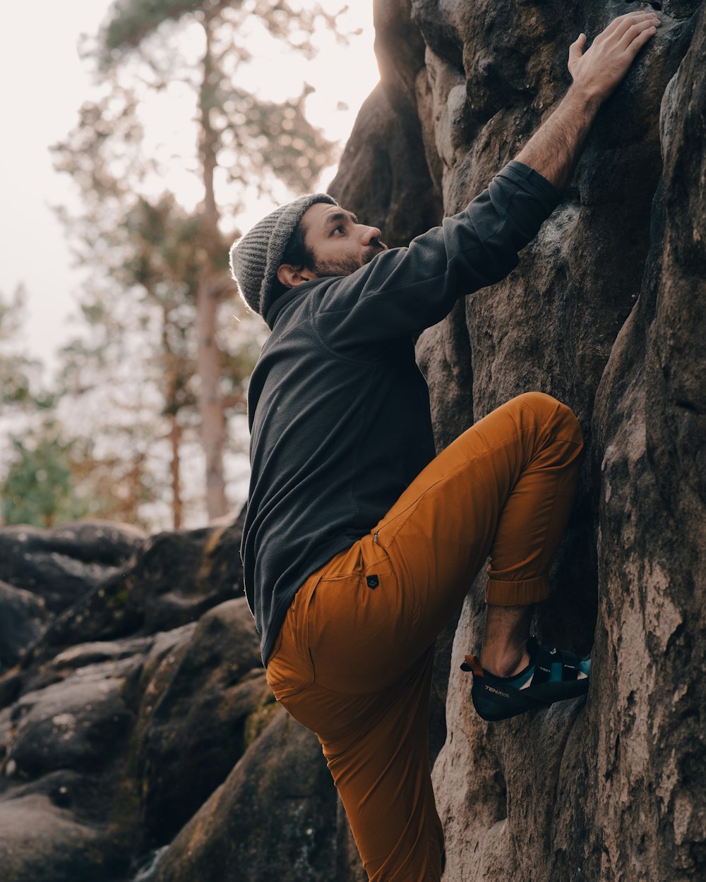 a man climbing up the side of a mountain