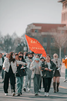 A group of determined women walking along a scenic highway, carrying signs and backpacks, with the vast American landscape stretching behind them.
