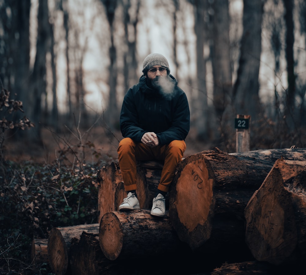 Un hombre sentado en un tronco en el bosque