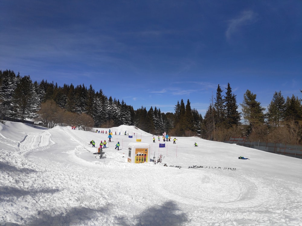 a group of people riding down a snow covered slope